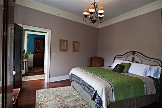 A bedroom with a large bed and a chandelier