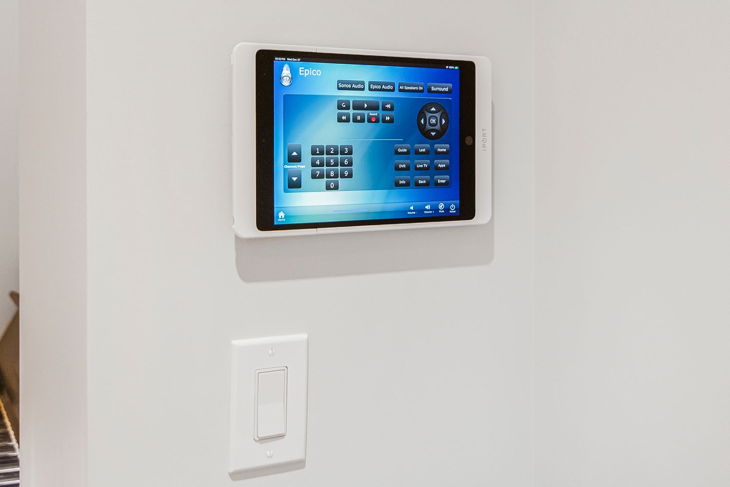 a tablet is mounted on a wall next to a light switch .