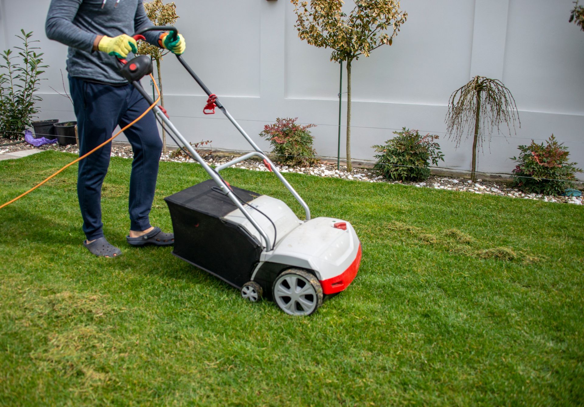 A man is using a lawn mower to mow the grass.