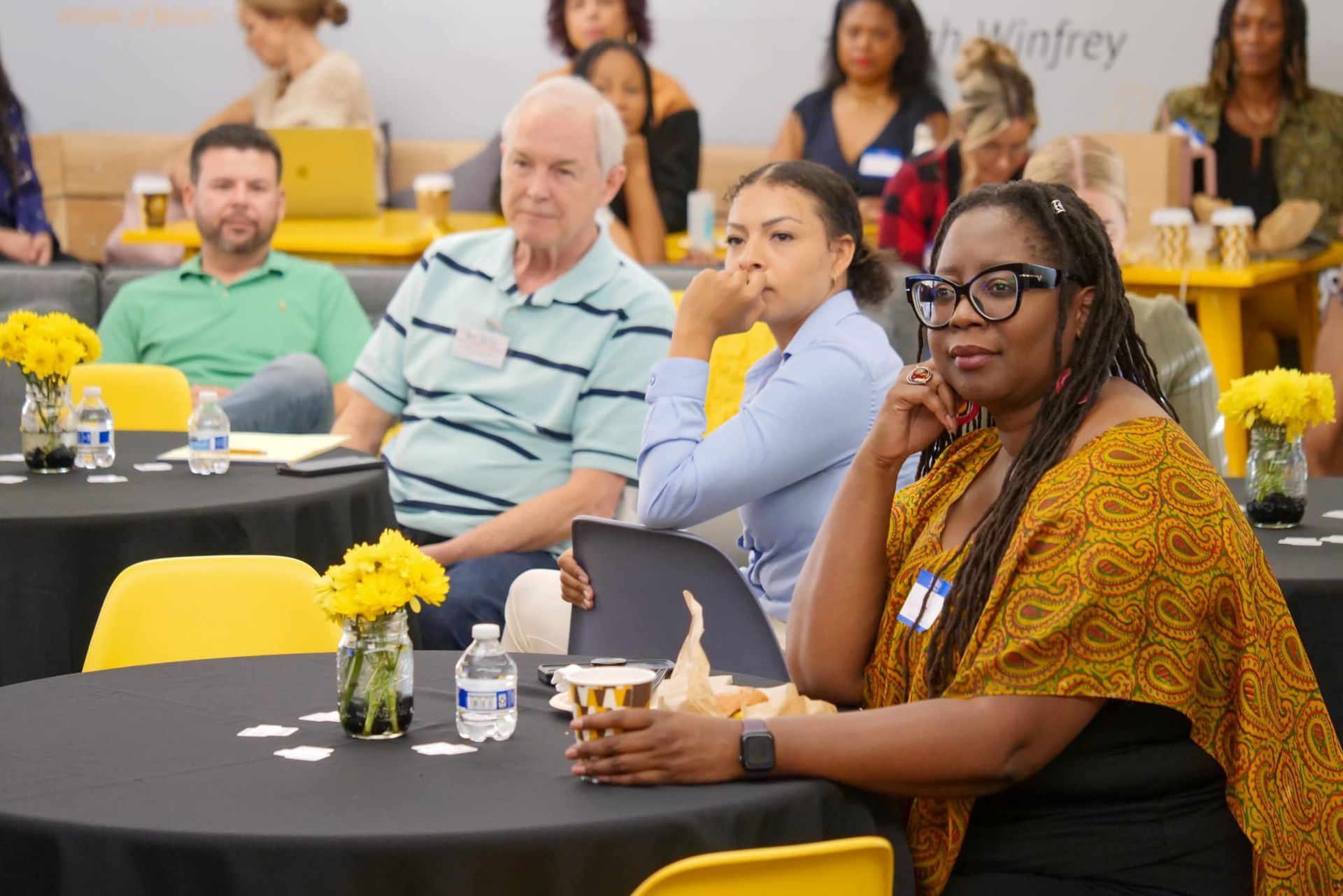 Empty classroom with rows of desks and chairs, orange and grey color scheme, American flag.
