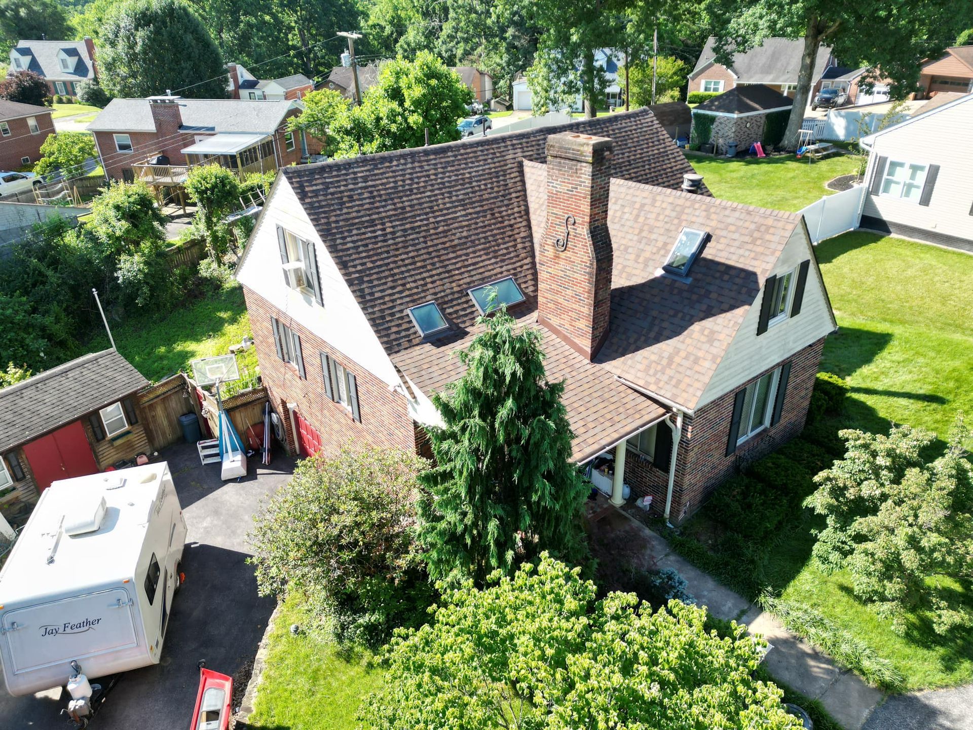 An aerial view of a house with a trailer parked in front of it.