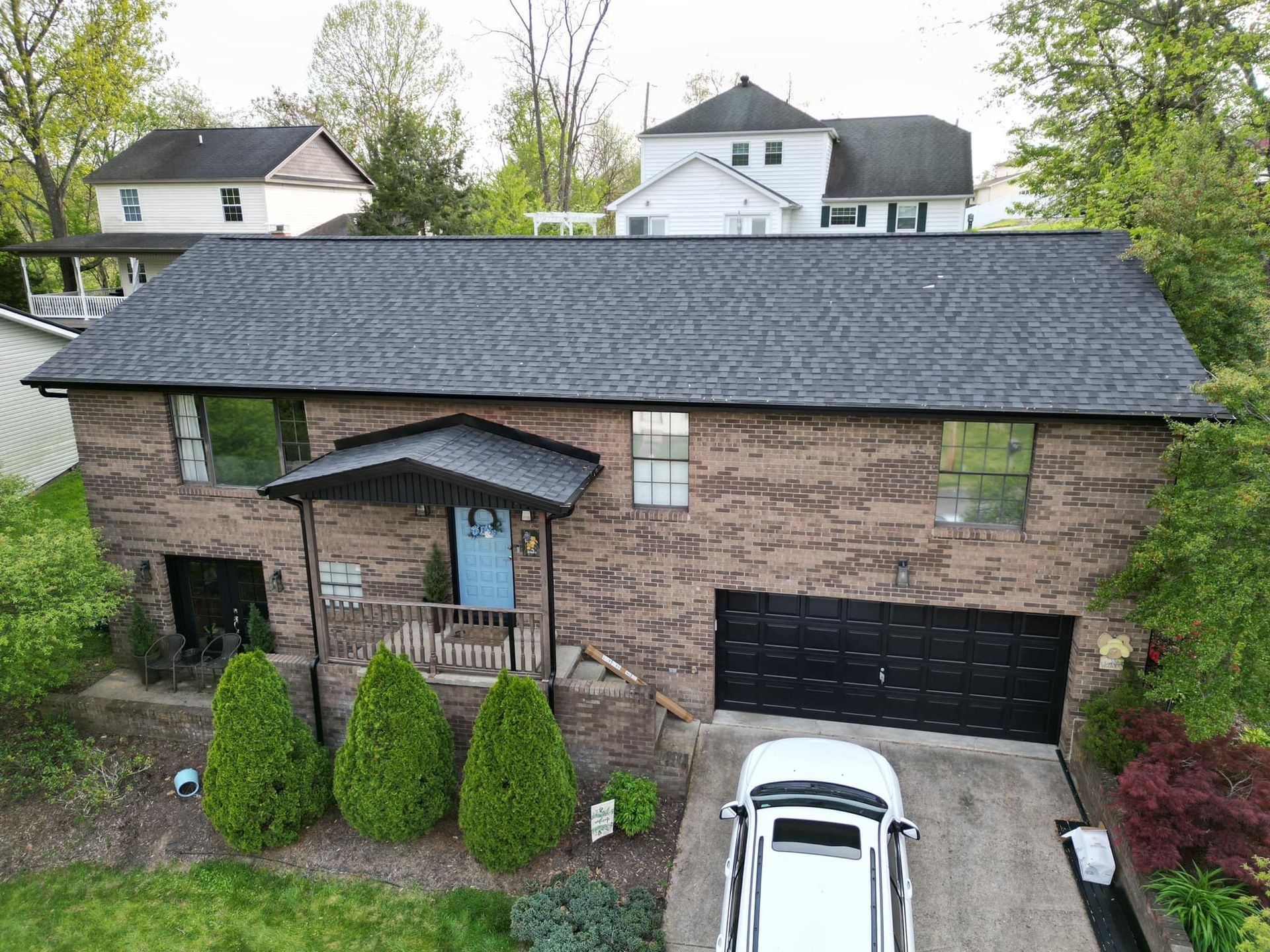 An aerial view of a brick house with a car parked in front of it.