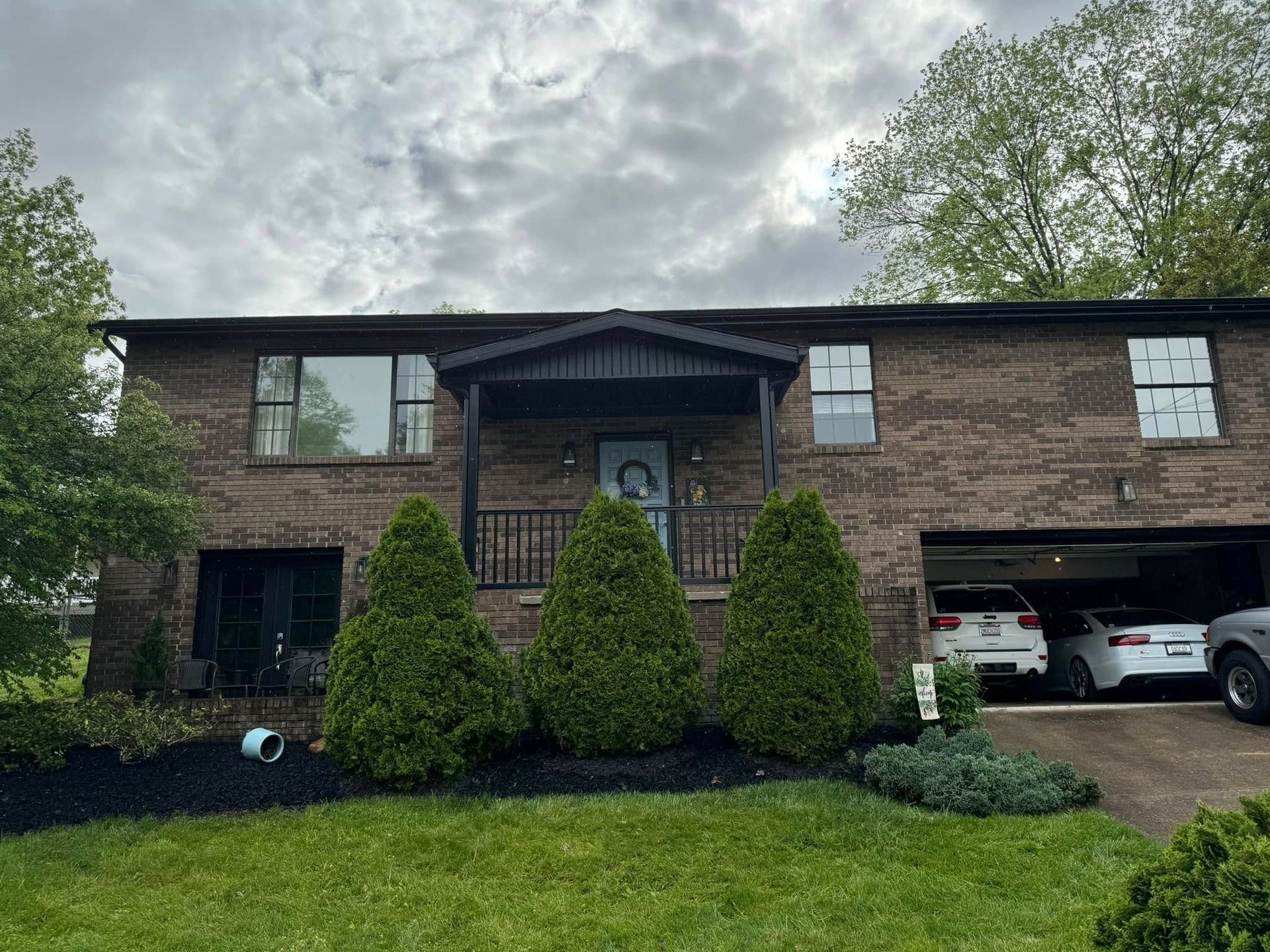 A large brick house with a car parked in front of it.
