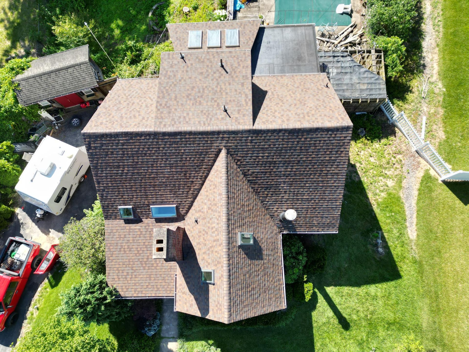 An aerial view of a house with a roof that has skylights on it.