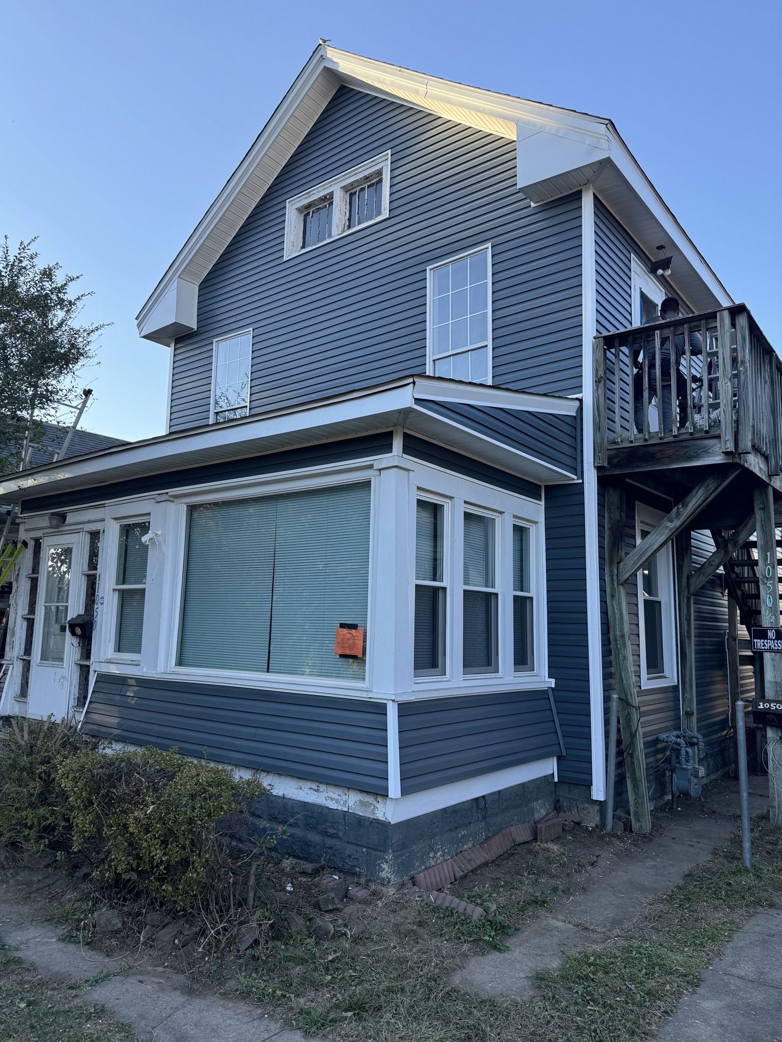 A large house with a balcony and stairs on the side of it.