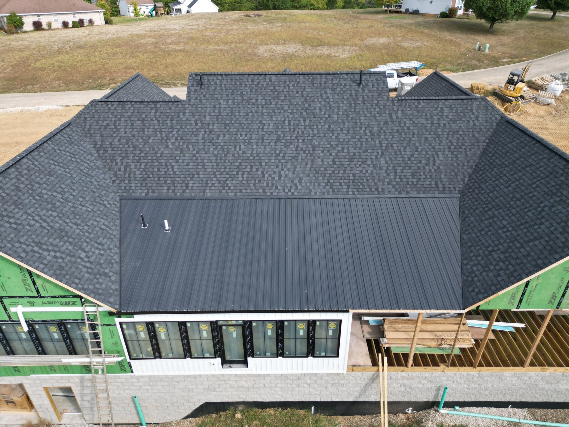 An aerial view of a house under construction with a black roof.