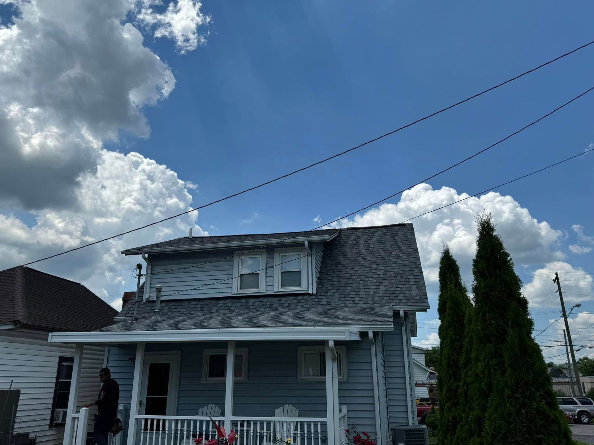 A house with a porch and a blue sky in the background.