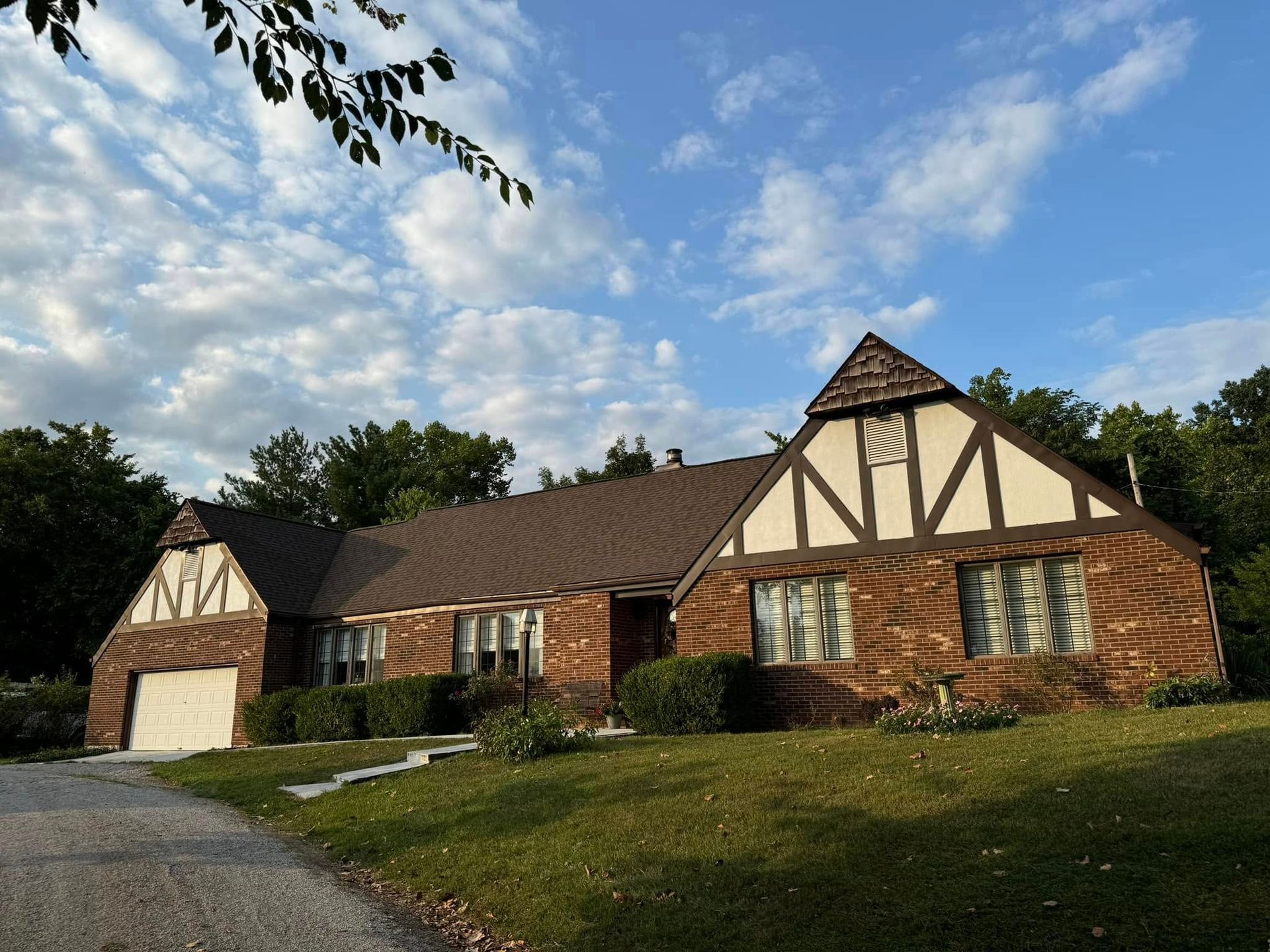 A brick house with a brown roof and white trim