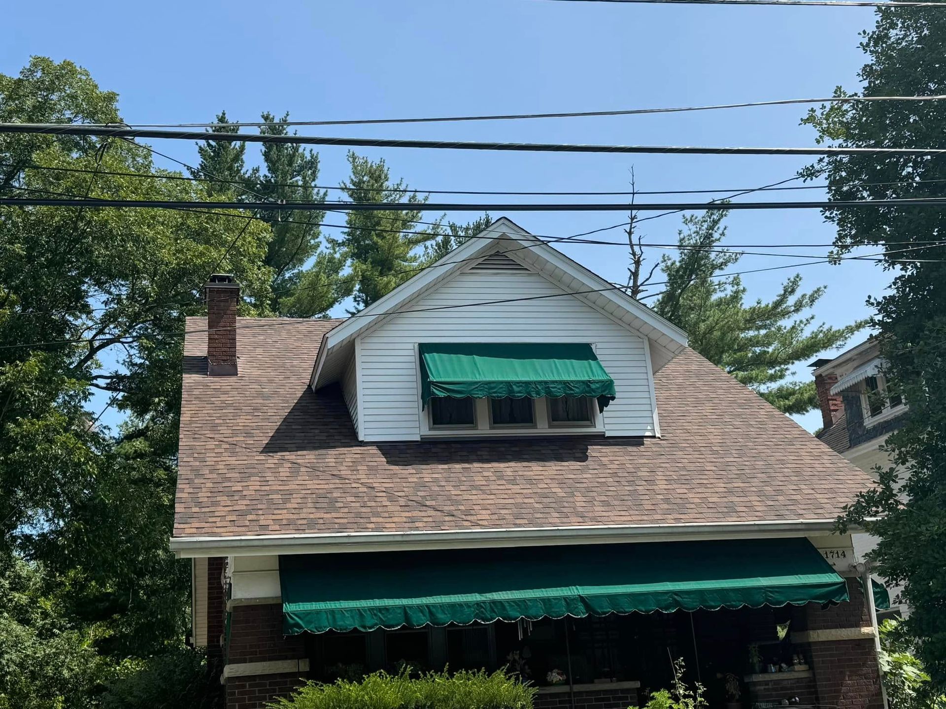 A house with a green awning on the front of it