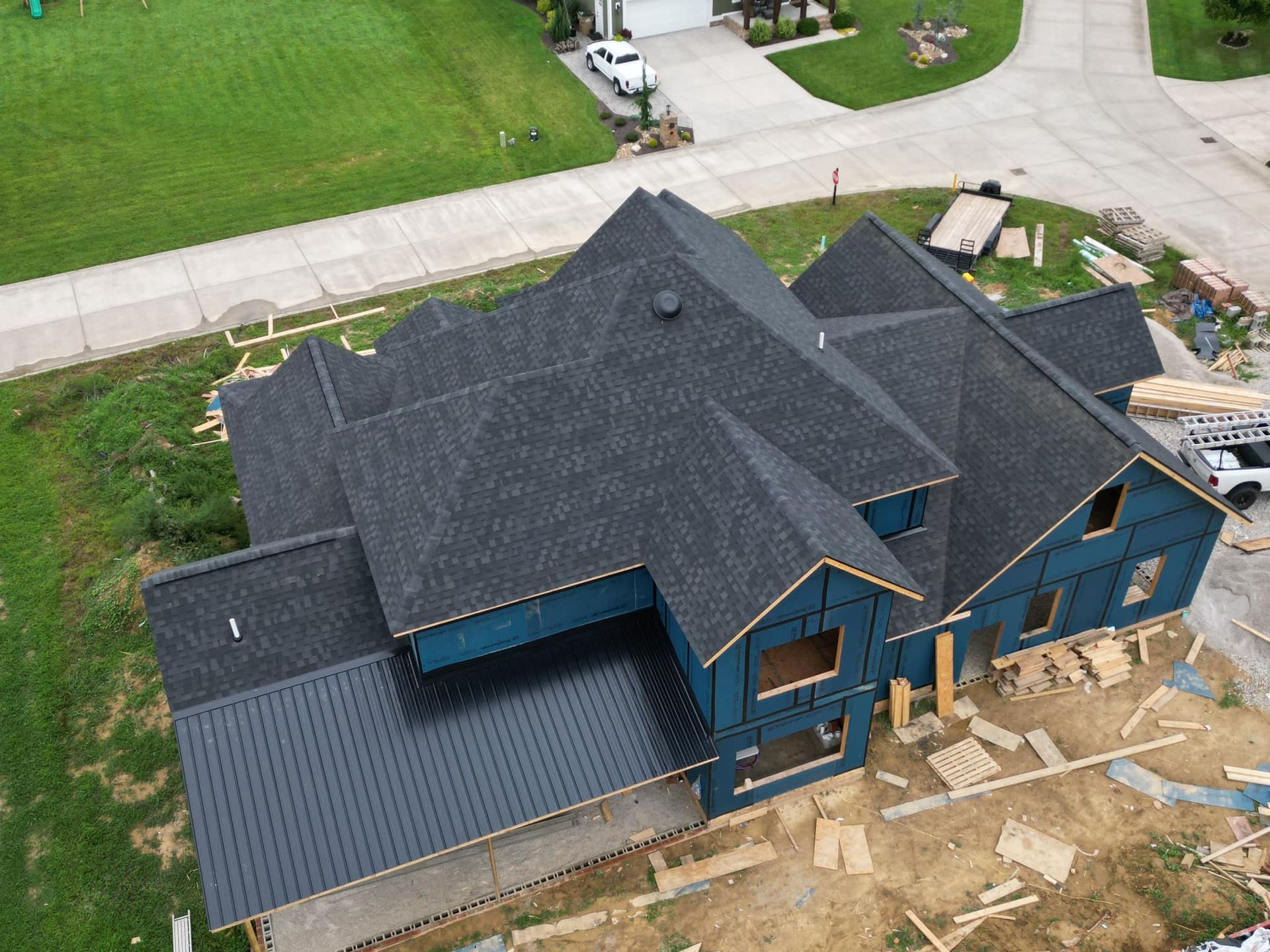 An aerial view of a house under construction with a black roof.
