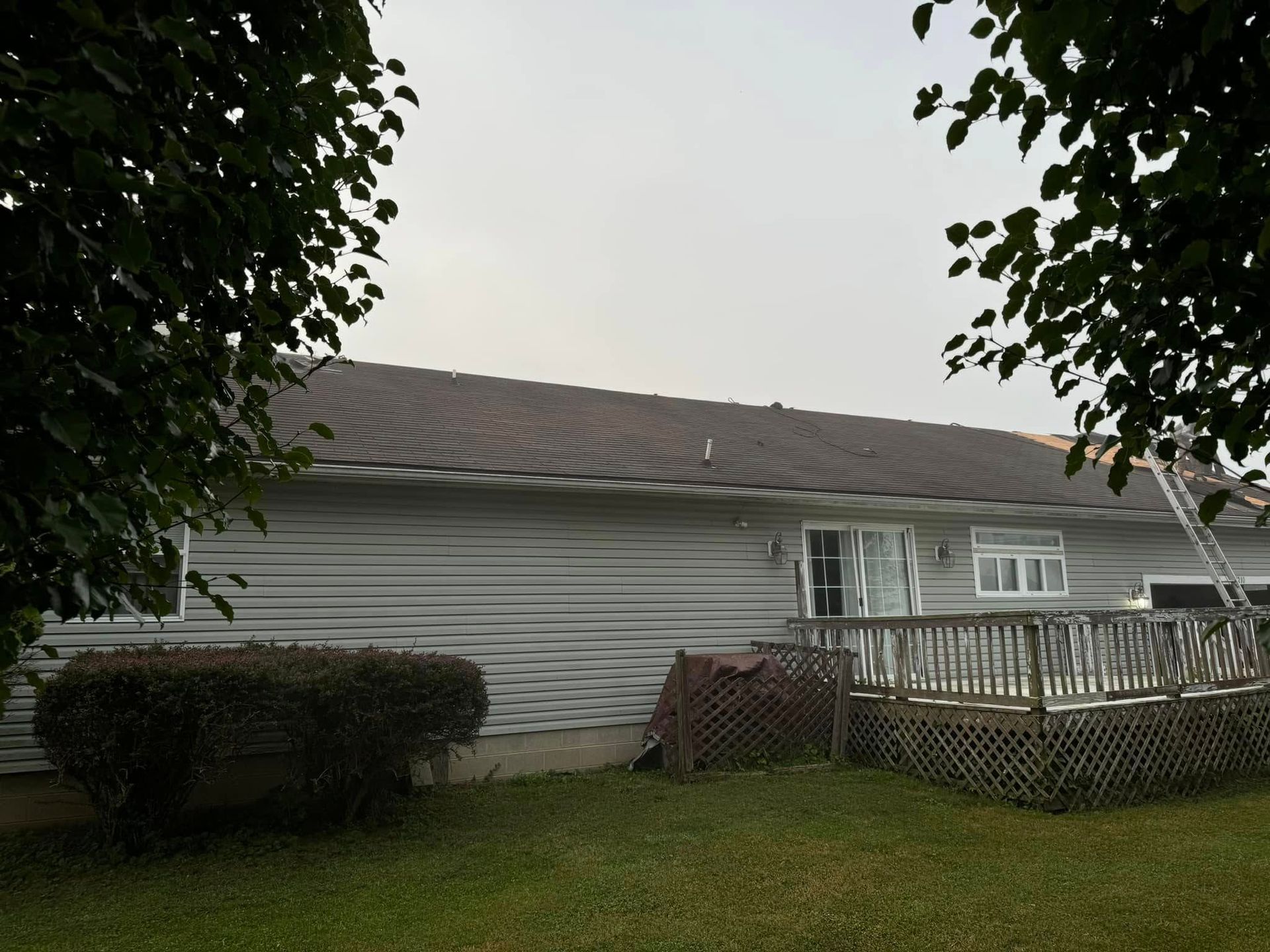 A house with a deck and a ladder in the backyard