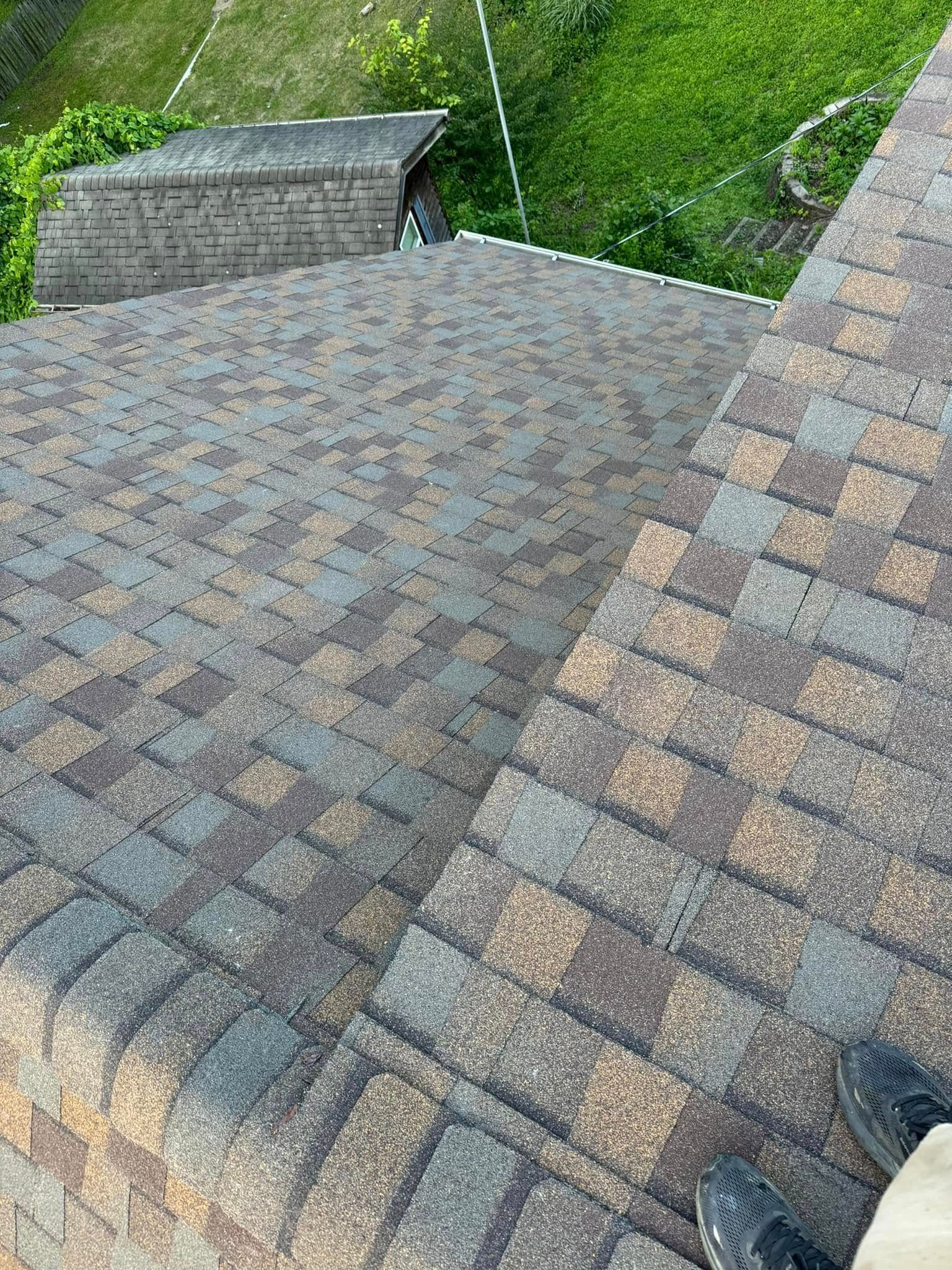A person is standing on the roof of a house.