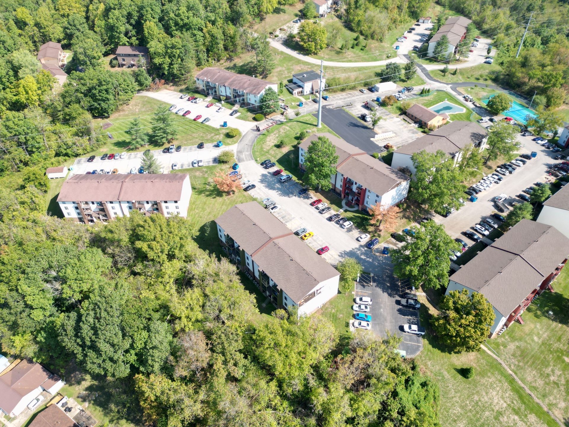 An aerial view of a residential area with lots of trees and buildings