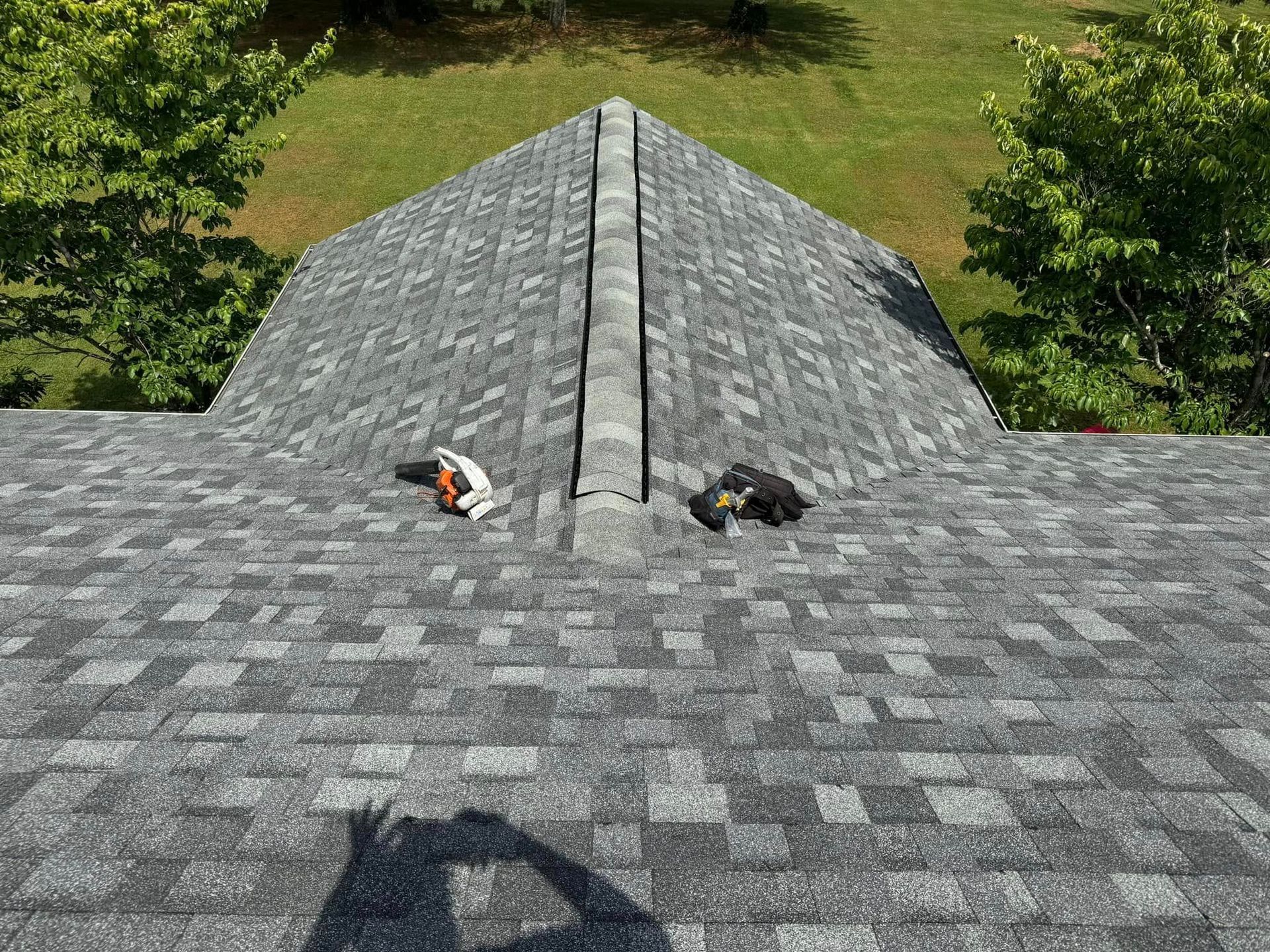 A roof with a shadow of a person on it.