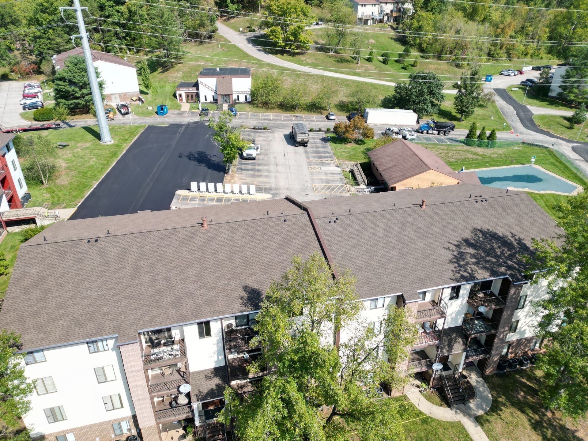 An aerial view of a building with a pool in the middle of it.