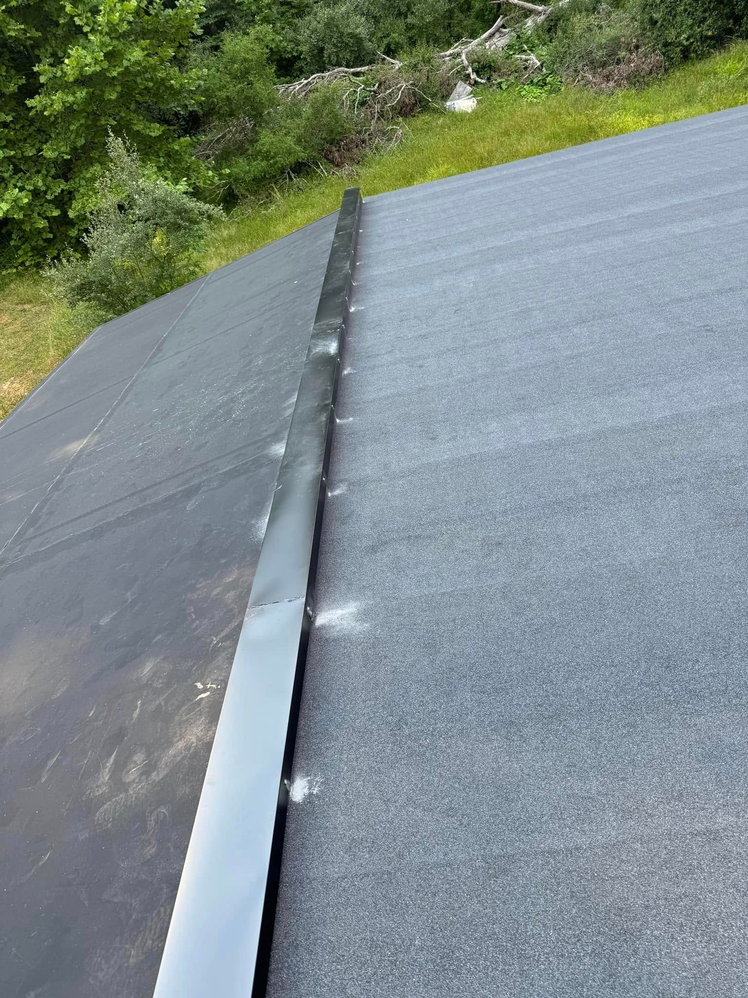 A close up of a roof with a metal gutter on it.