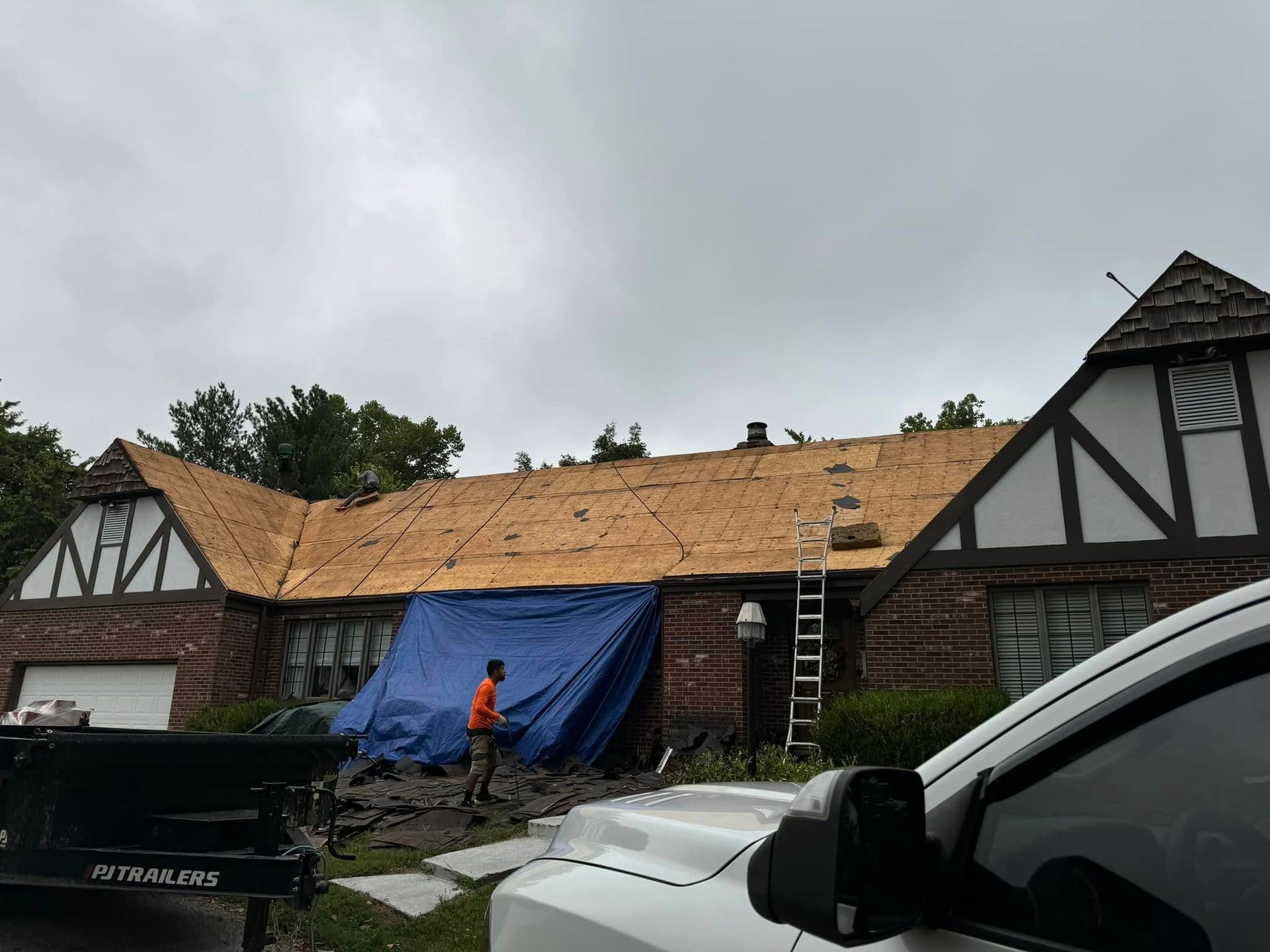 A white truck is parked in front of a house that is being remodeled.
