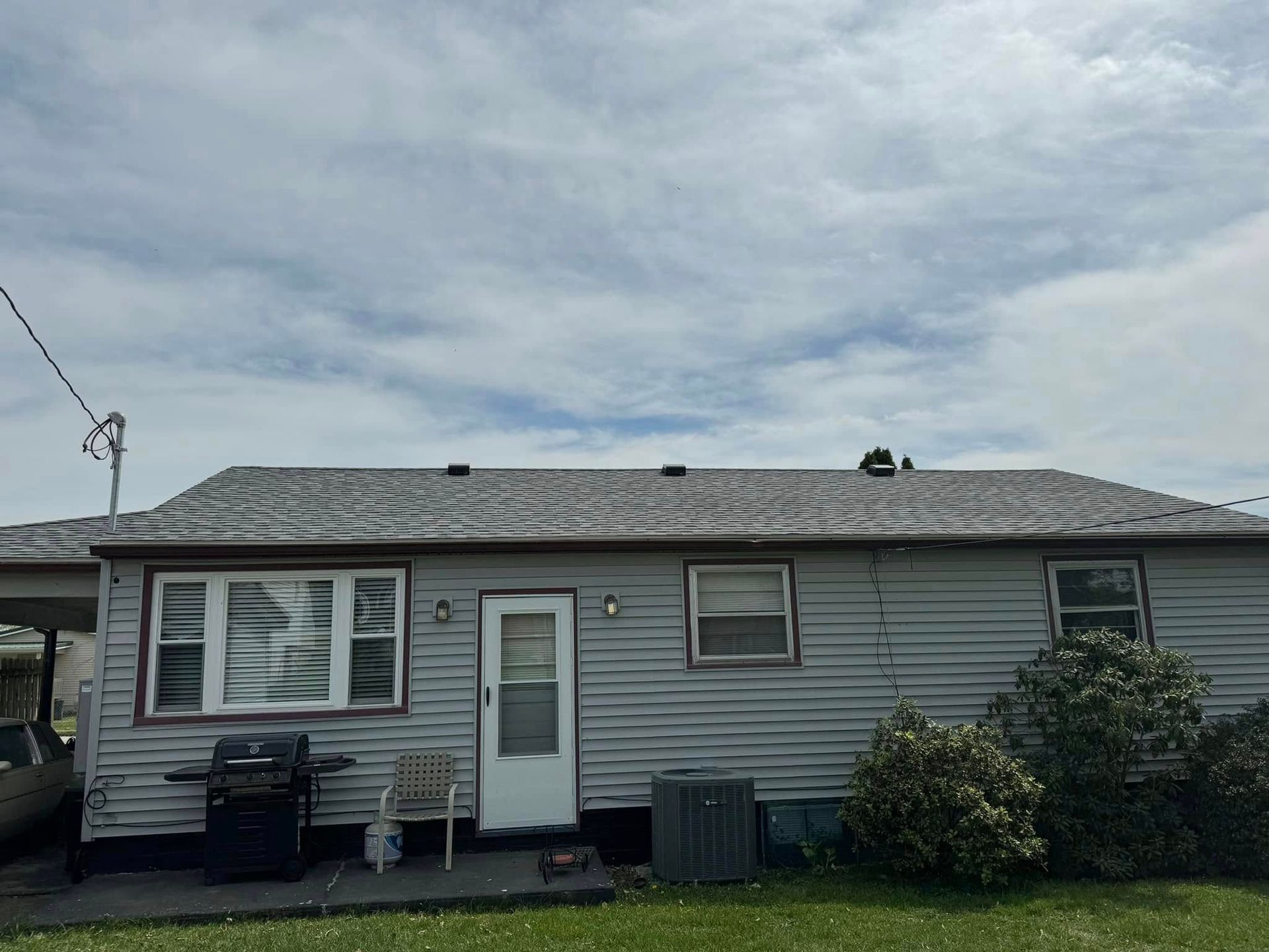 A small house with a roof that is missing shingles.