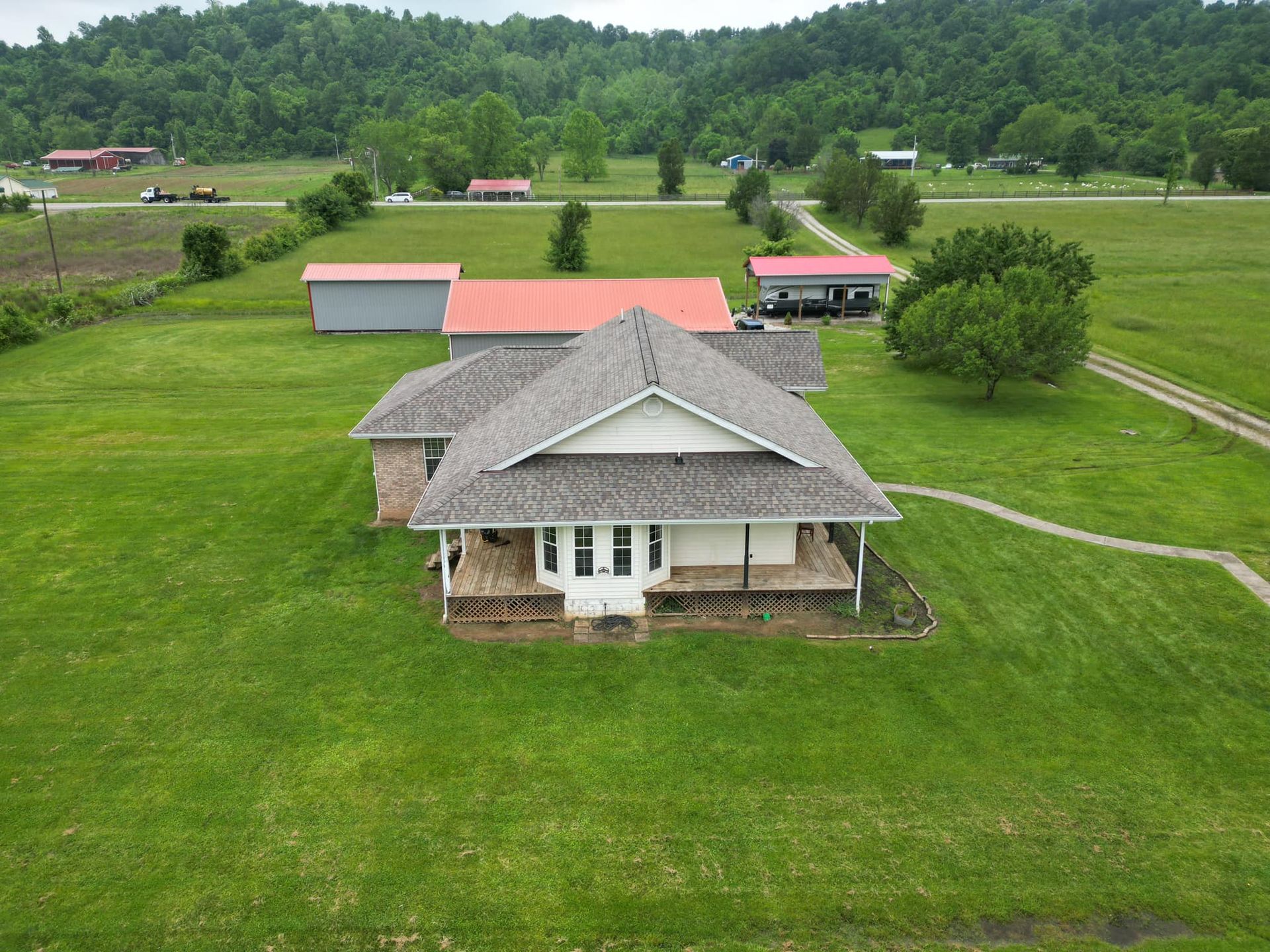 An aerial view of a house in the middle of a lush green field.