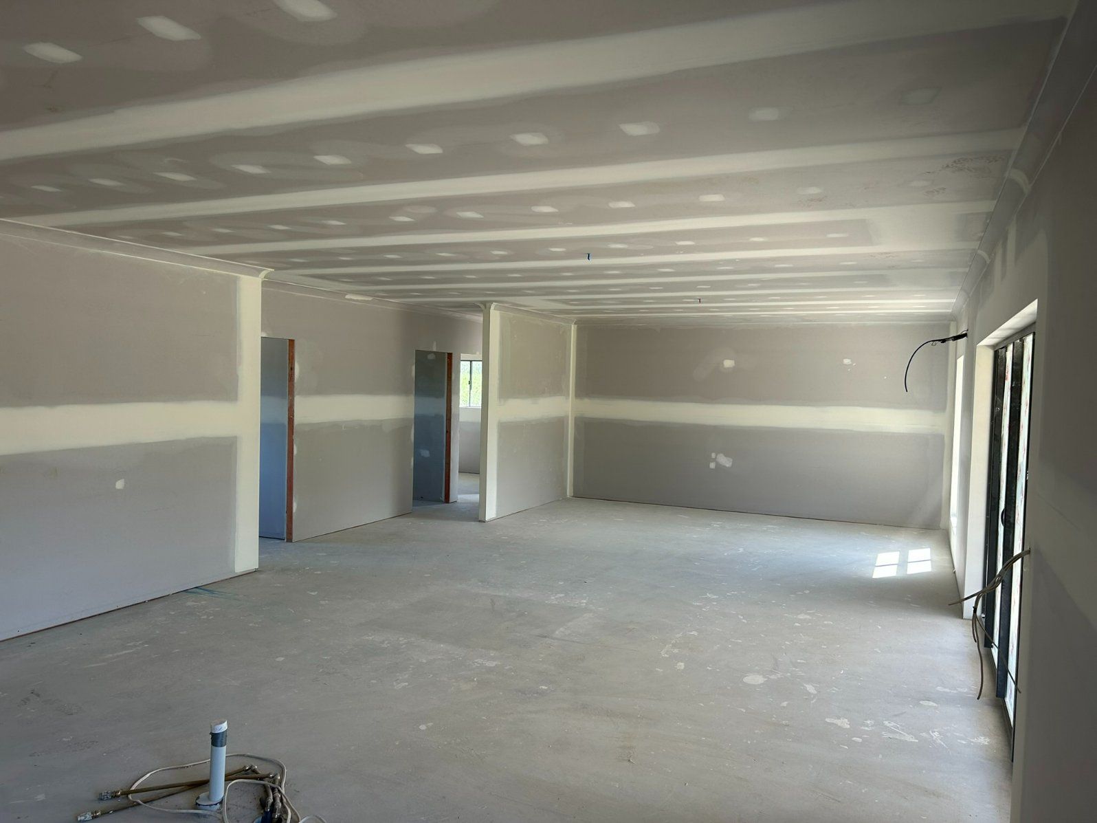 A Large Empty Room With a Ceiling — Hams Plastering in Cannonvale, QLD