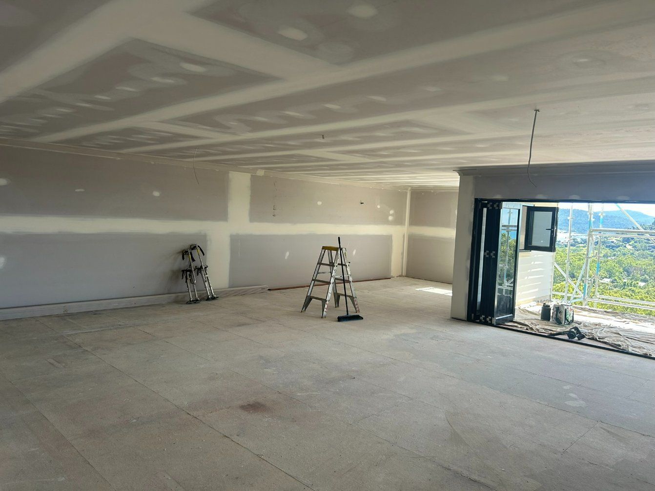 An Empty Room With a Ladder — Hams Plastering in Cannonvale, QLD
