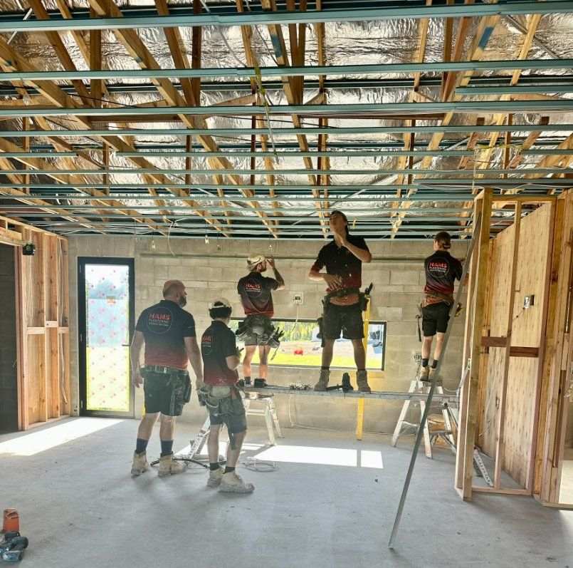 A Group of Men Are Working on a Ceiling — Hams Plastering in Cannonvale, QLD