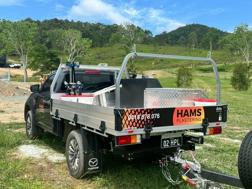 A Truck With a Trailer Attached to It is Parked — Hams Plastering in Cannonvale, QLD