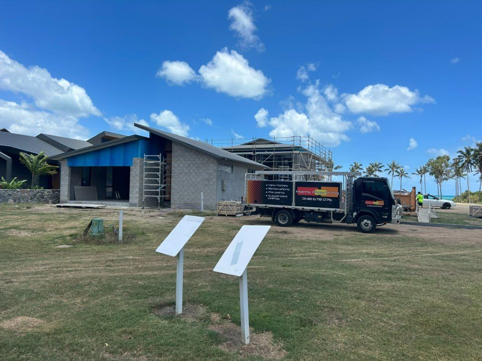 A Truck is Parked in Front of a House Under Construction — Hams Plastering in Cannonvale, QLD
