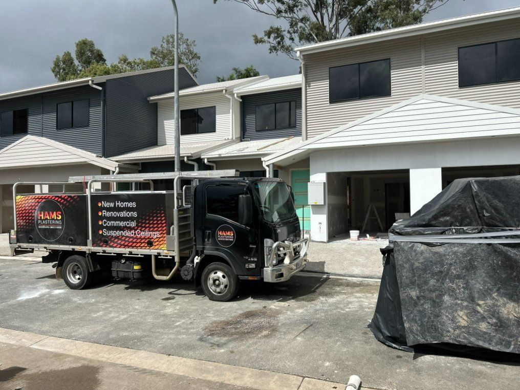 A Truck is Parked in Front of a House Under Construction — Hams Plastering in Cannonvale, QLD
