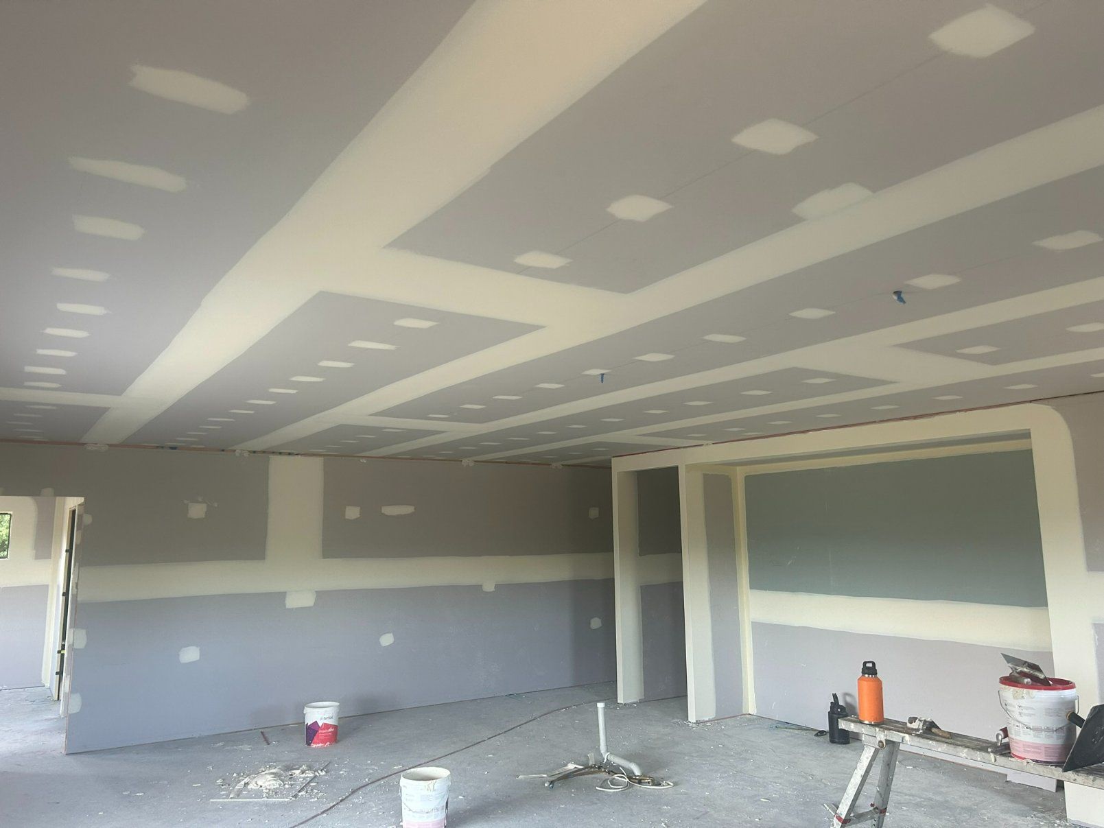 A Room With a Ladder and Buckets of Paint in It — Hams Plastering in Cannonvale, QLD