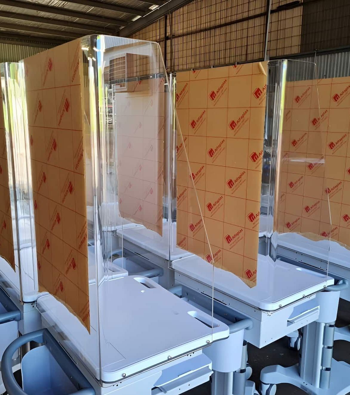 A Row Of Tables With Acrylic Dividers On Them Are Sitting In A Warehouse — Ram Star Plastics In Winnellie, NT