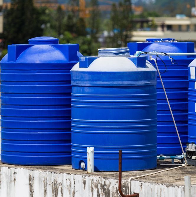 A Row Of Blue Water Tanks Are Sitting On Top Of A Building — Ram Star Plastics In Winnellie, NT