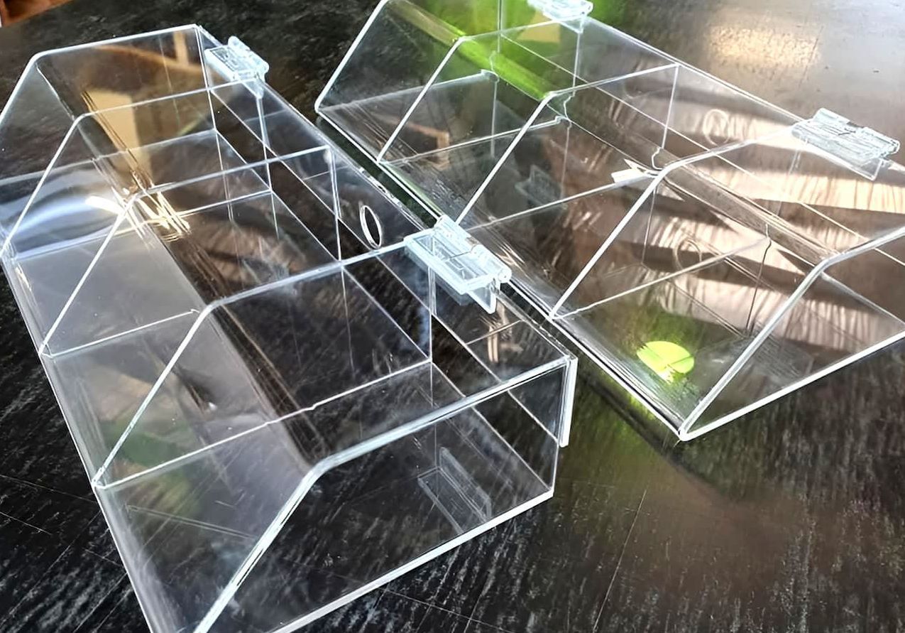 Two Clear Acrylic Boxes Are Sitting On A Black Table — Ram Star Plastics In Winnellie, NT