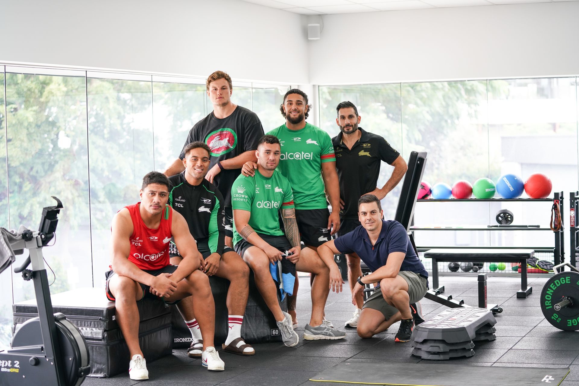 A group of men are posing for a picture in a gym.
