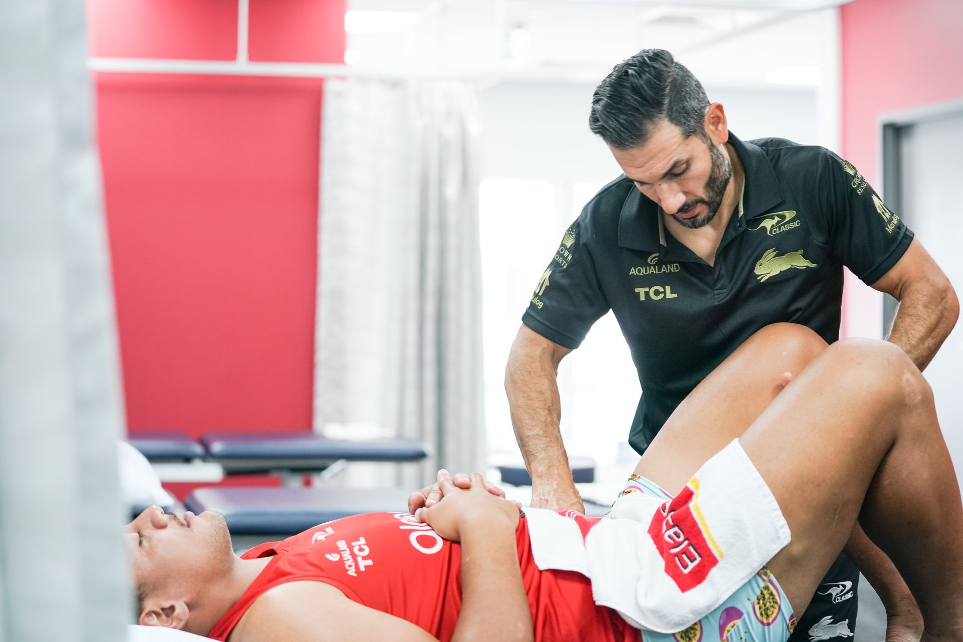 A man is giving a woman a massage in a hospital room.