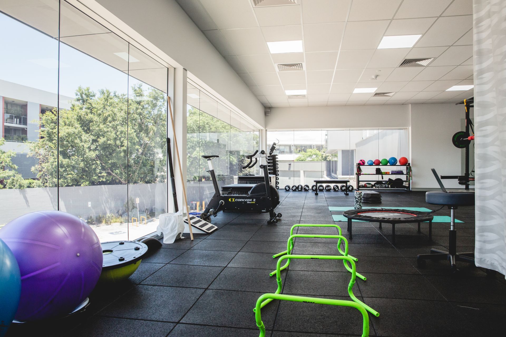 A gym with a lot of equipment and a large window.