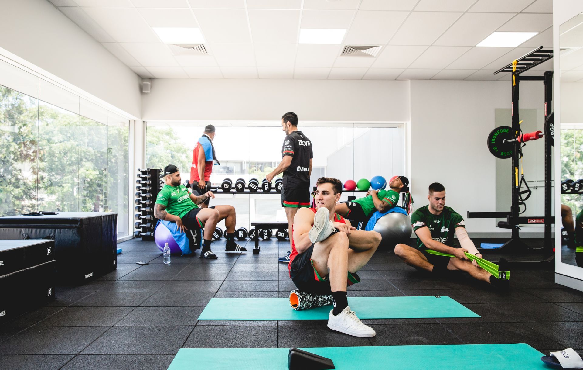 A group of men are doing exercises in a gym.