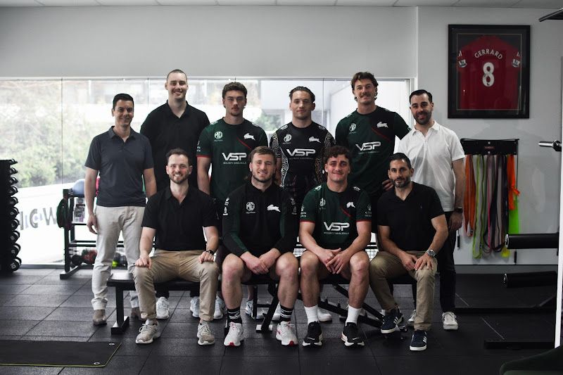 A group of men are posing for a picture in a gym.