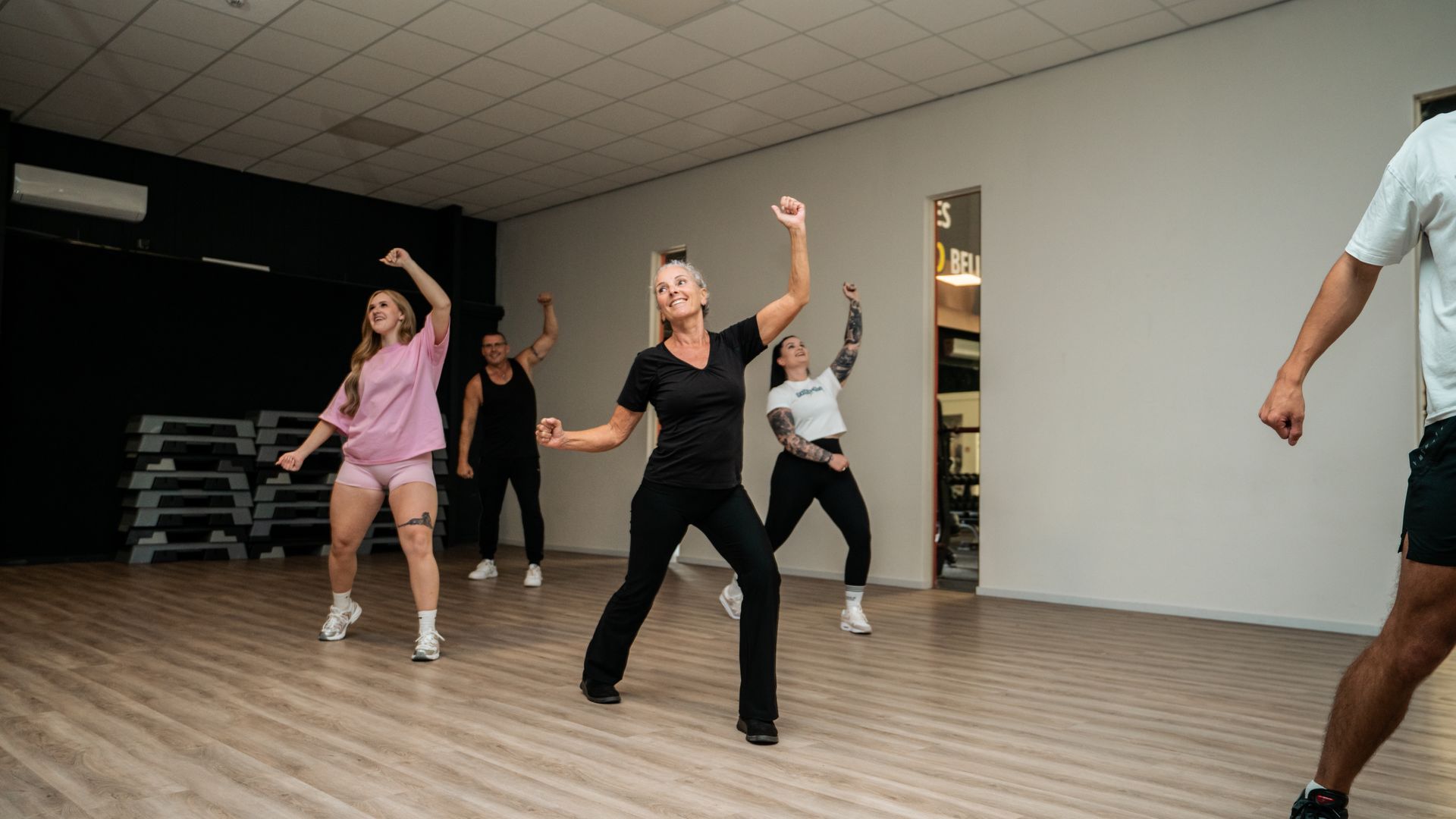 Man doet een bergbeklimmersoefening op een mat in een sportschool met uitzicht op de stad.