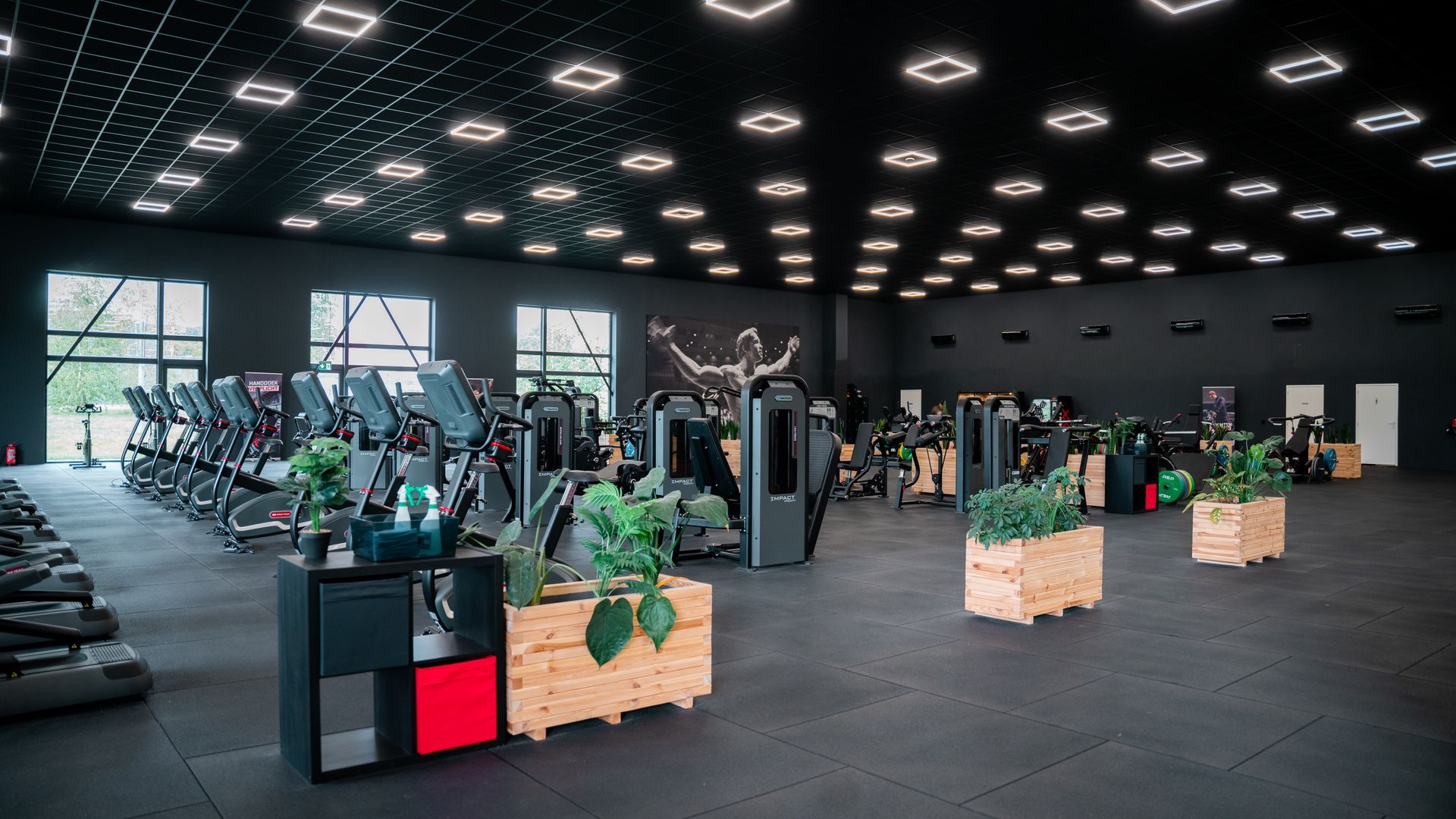 Rijen zwarte halters op een rek in een sportschool.