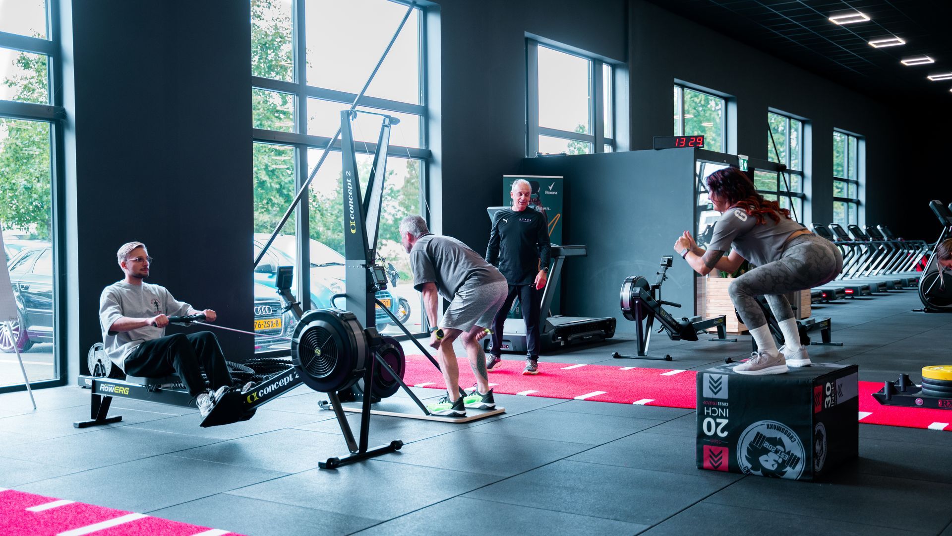 Vrouwen in sportkleding, waaronder een zwarte vrouw, in de sportschool, die zich voorbereiden op hun training.