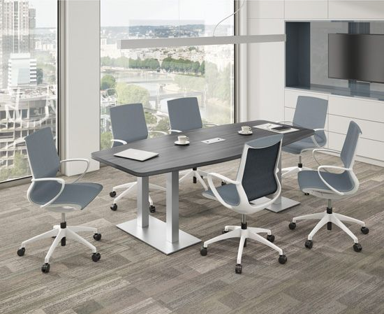 Conference room with grey table, six grey and white chairs, near a window with city view.