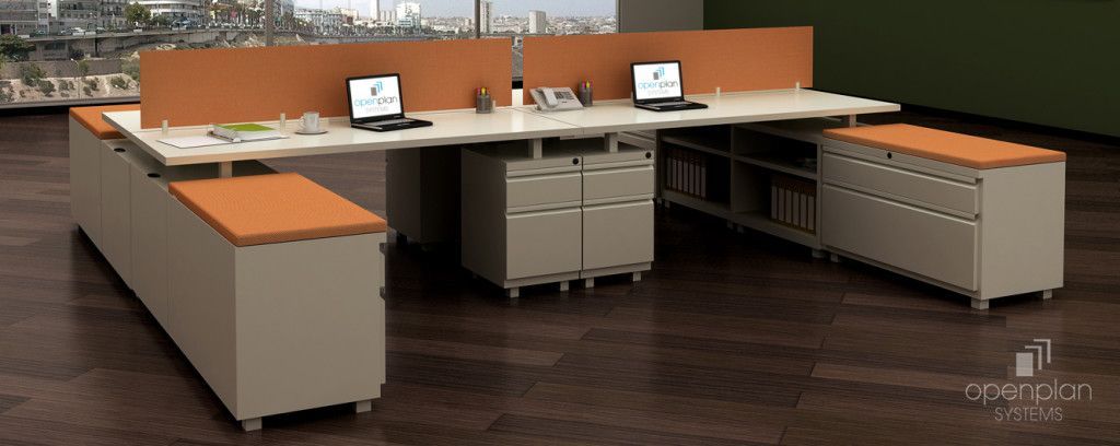 Office cubicles with desks, dividers, storage cabinets, laptops, and a window in the background.
