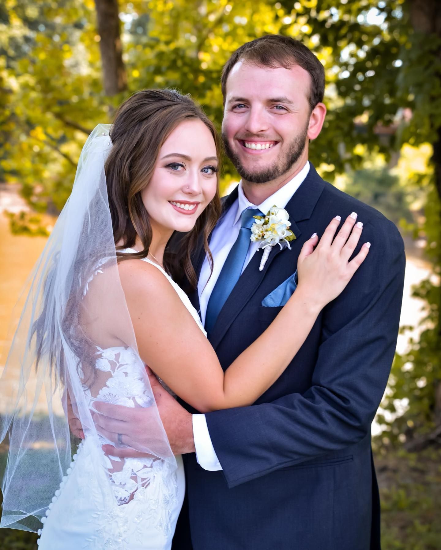 A bride and groom are posing for a picture on their wedding day.