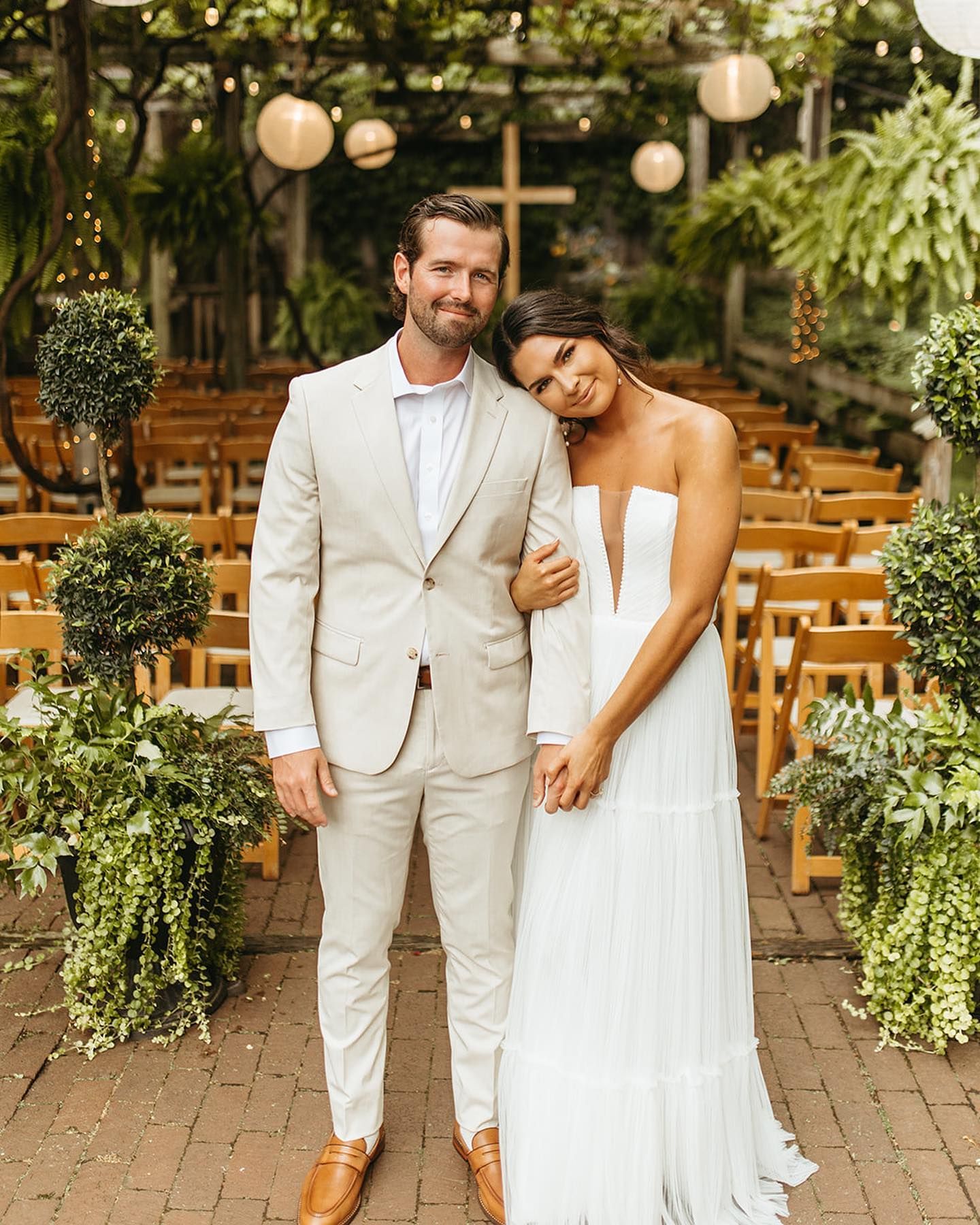 A bride and groom are posing for a picture at their wedding ceremony.