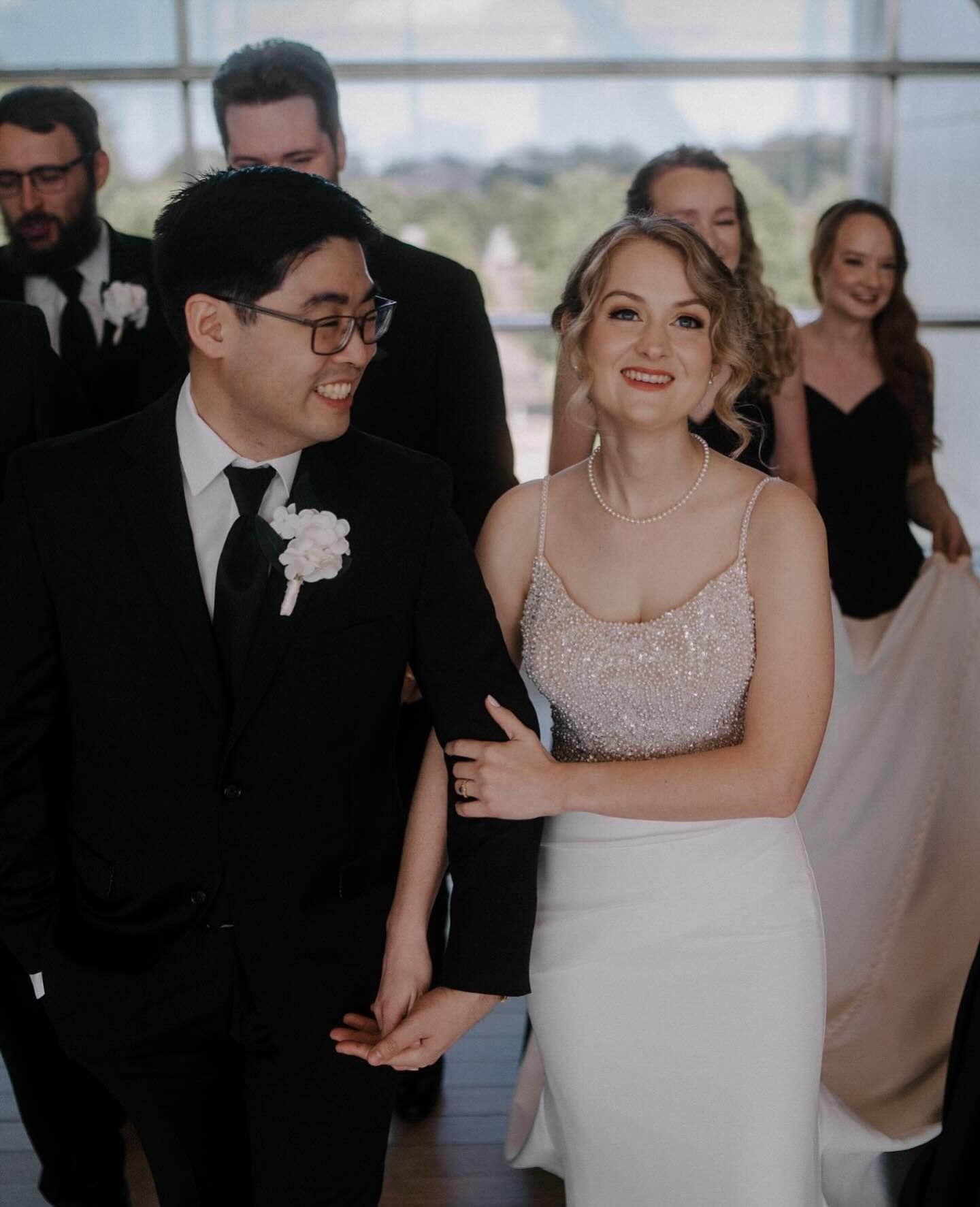 A bride and groom are walking down the aisle with their wedding party.