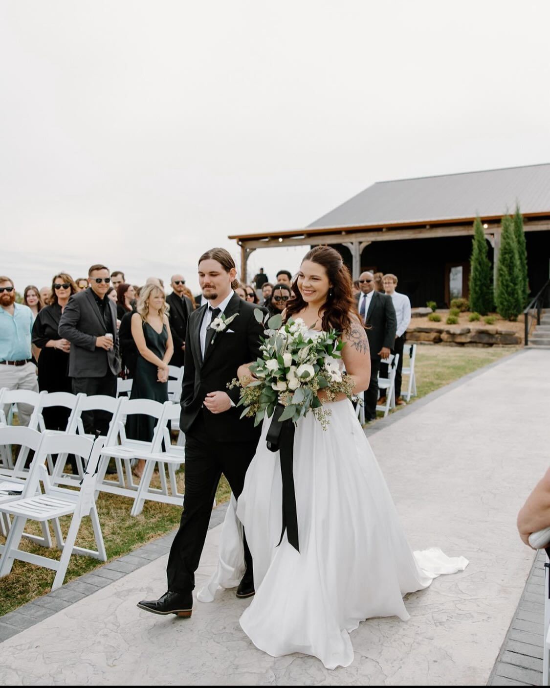 A bride and groom are walking down the aisle at their wedding.