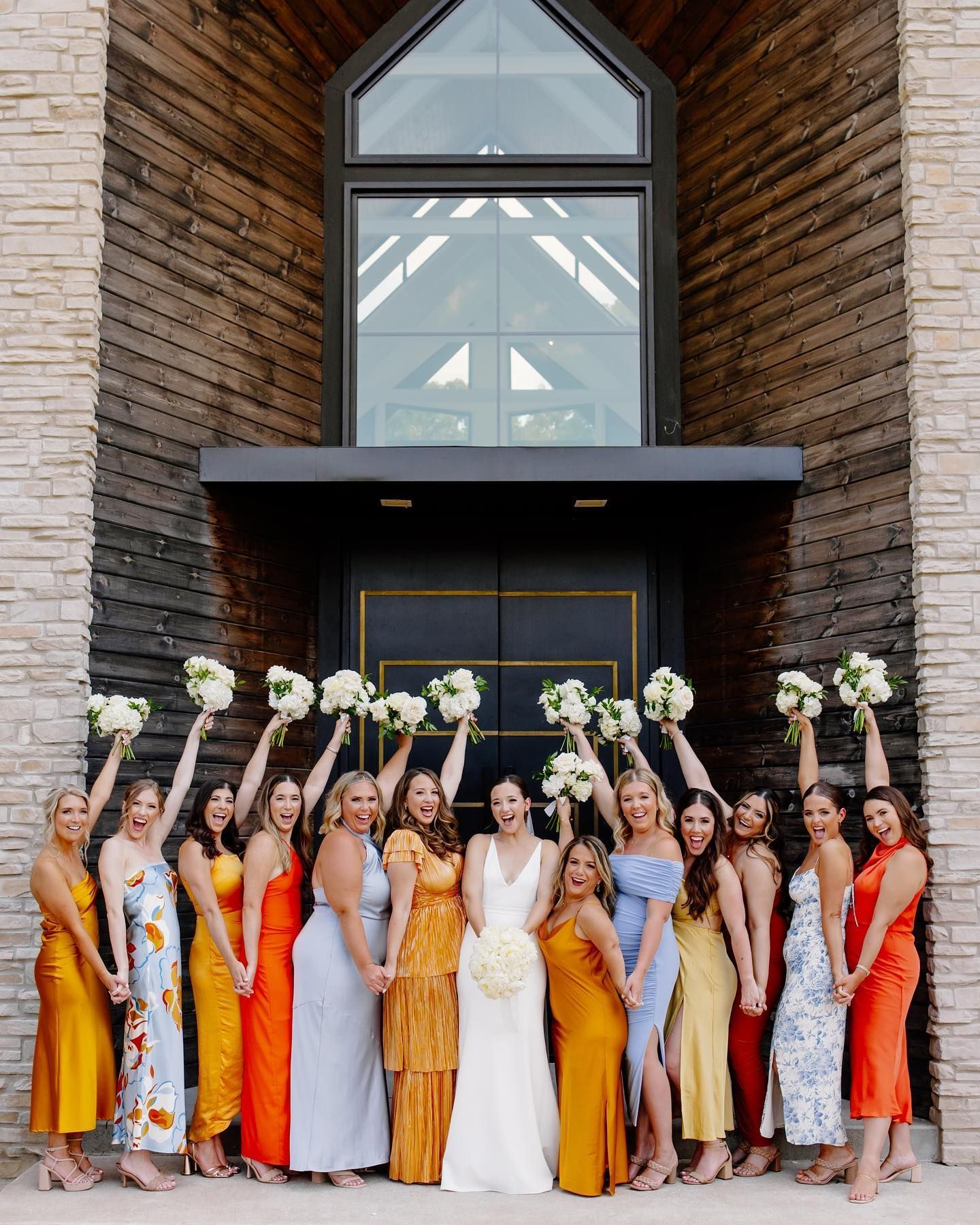 A bride and her bridesmaids are posing for a picture in front of a building.
