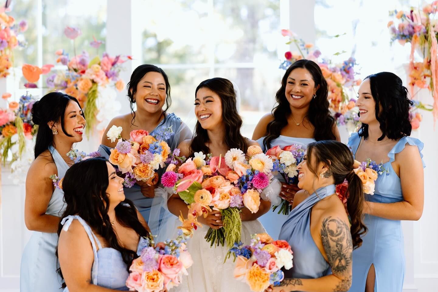 A bride and her bridesmaids are posing for a picture.