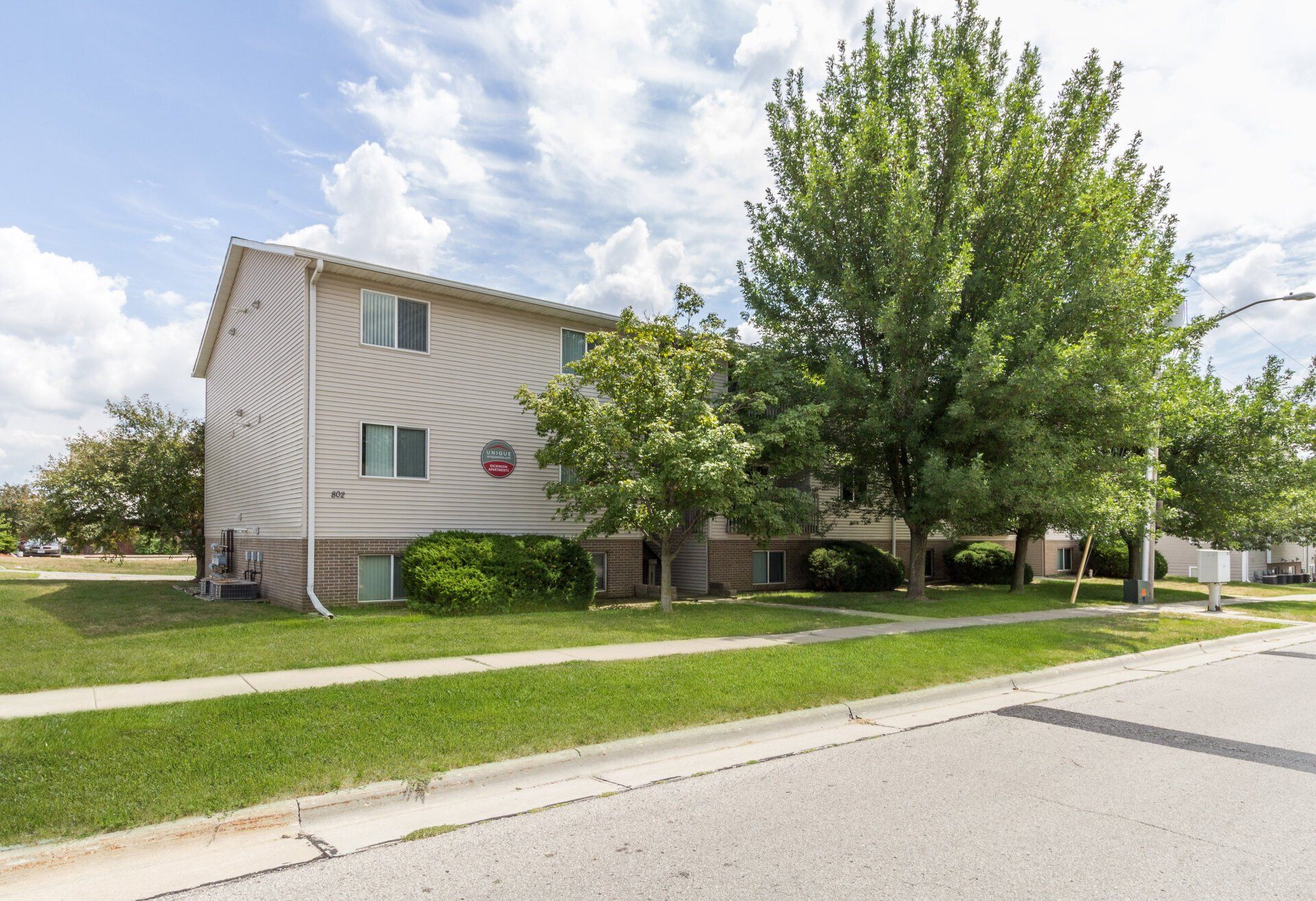 Exterior view of 802 Dickinson, a modern apartment building in Ames, IA offering convenient living spaces close to local & ISU amenities.
